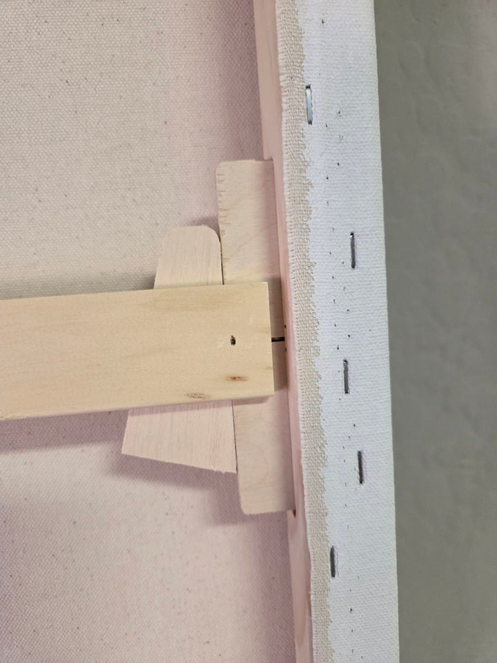 Wooden T-shaped tool on a textured surface. Close-up of a wooden trim detail, tightening wedge.